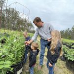 Travis Hammonds tends his garden with his children at their home in Alabama. Hammonds says donating their extra harvest to their local food bank helps fight food insecurity in their community and teaches his children the importance of giving back.